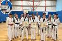 Peterborough instructor and Ely student Christopher Benstead, Wisbech student Charlotte Beck and Ely students Jack Steventon and Natalia Teli (Inset) with their black belt certificates.