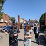Lucy Frazer out in Ely with a police office and the police and crime commissioner.