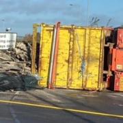 A lorry has overturned at the Lancaster Way roundabout near Witchford this morning, causing oil and materials to spill out. 
