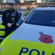 Police constable Sam Shepherd, who is based at Cambridgeshire Constabulary's headquarters, is pictured with his road policing unit car.